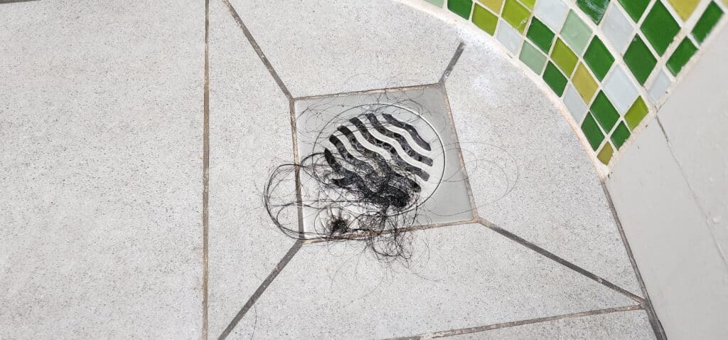 Hair stuck in the drain of a shower